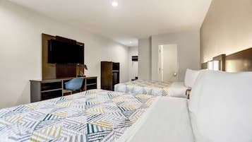 Une chambre d’hôtel avec deux lits, une télévision, un bureau et une chaise.