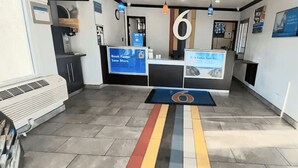 Zona de recepción con mostrador, un cartel grande con el número 6 y carteles informativos.