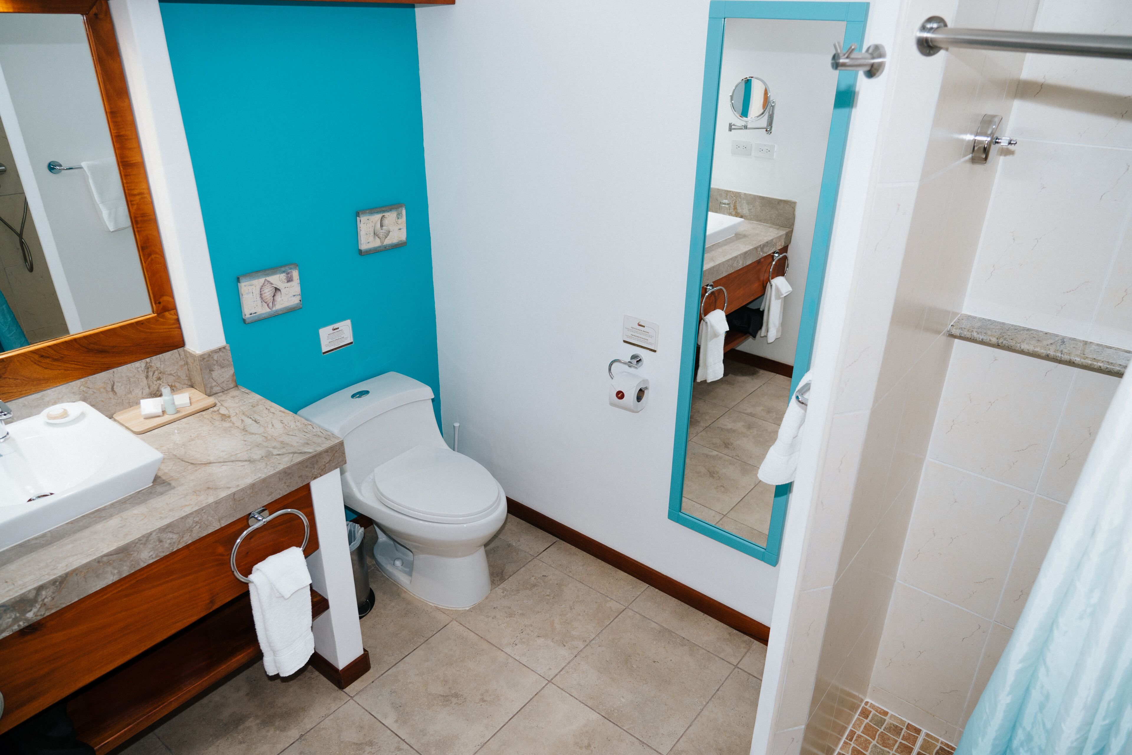 Un baño con lavamanos, inodoro y zona de ducha.