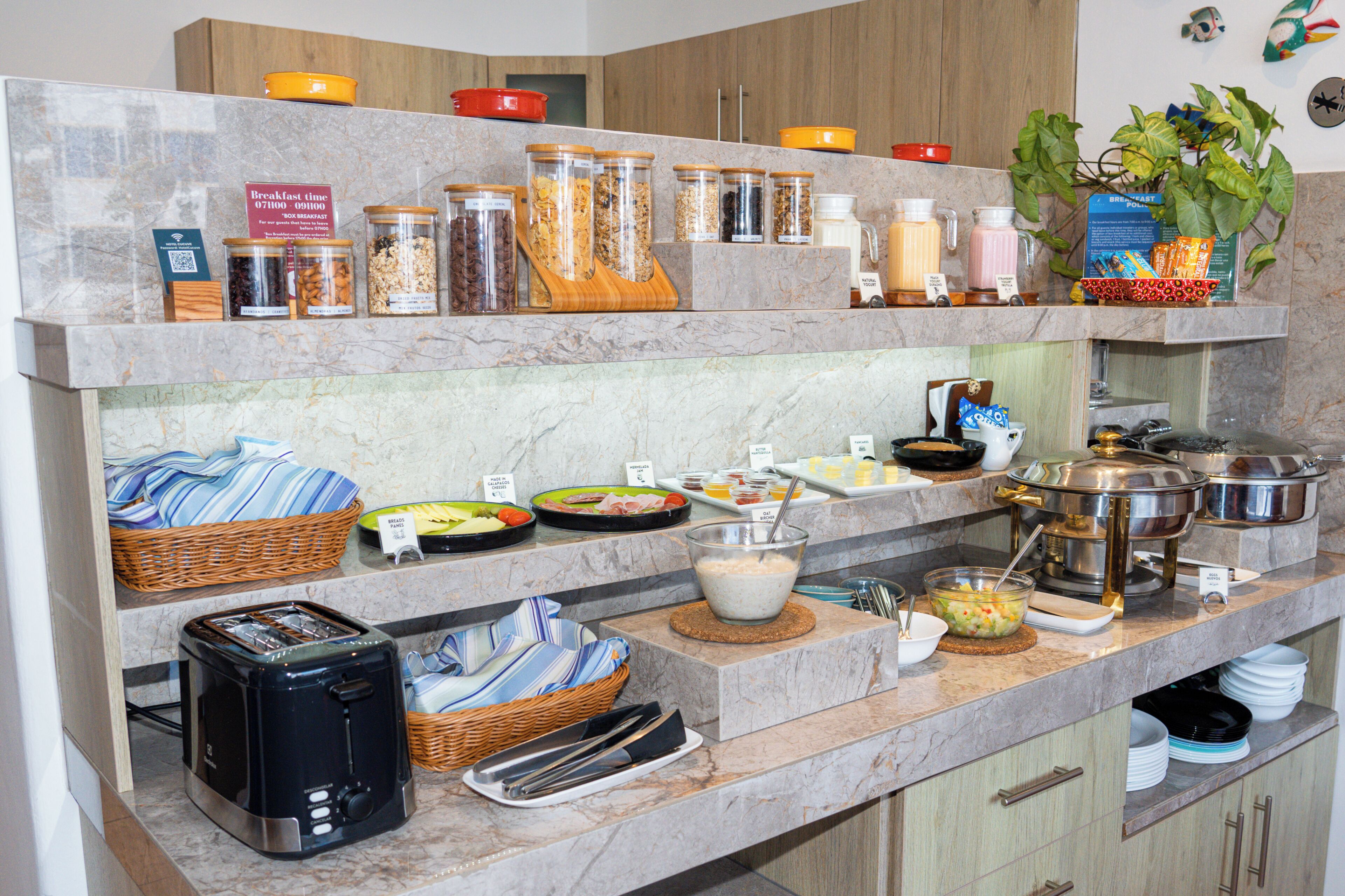 A breakfast buffet with various food items and utensils.