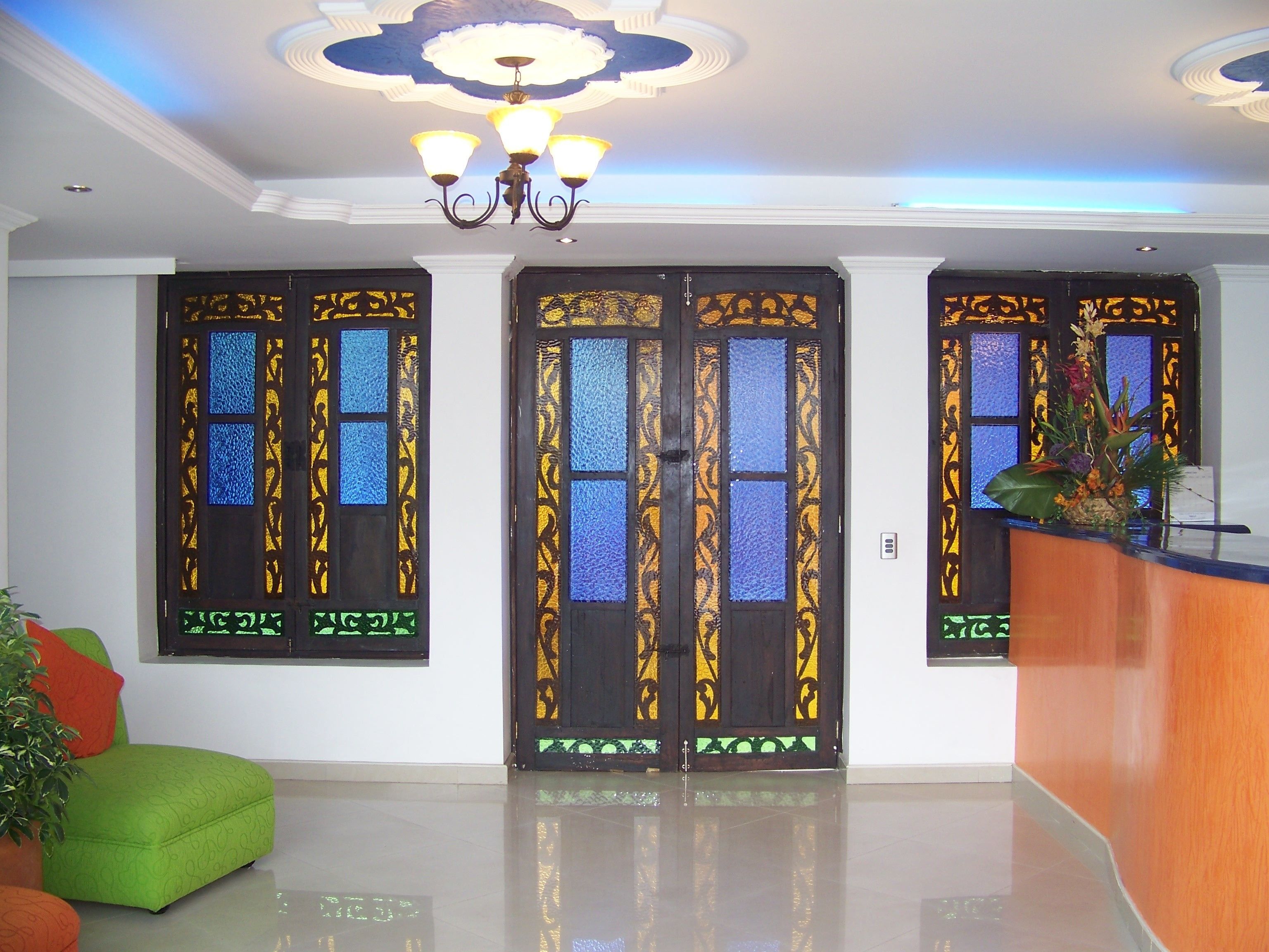 Un'area reception dal design moderno, con una scrivania, porte decorative e un lampadario.
