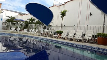 Una piscina al aire libre, tumbonas