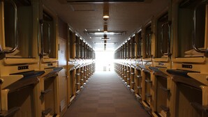 A long corridor with rows of identical rooms, each with a window and a door. - Sauna & Capsule Hokuoh - Cators to Men (Tokyo)