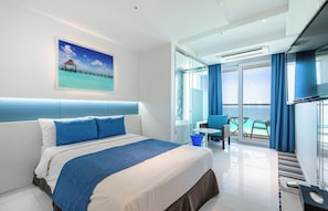 Een moderne hotelkamer met een groot bed, een balkon met uitzicht en een douchecabine van glas.