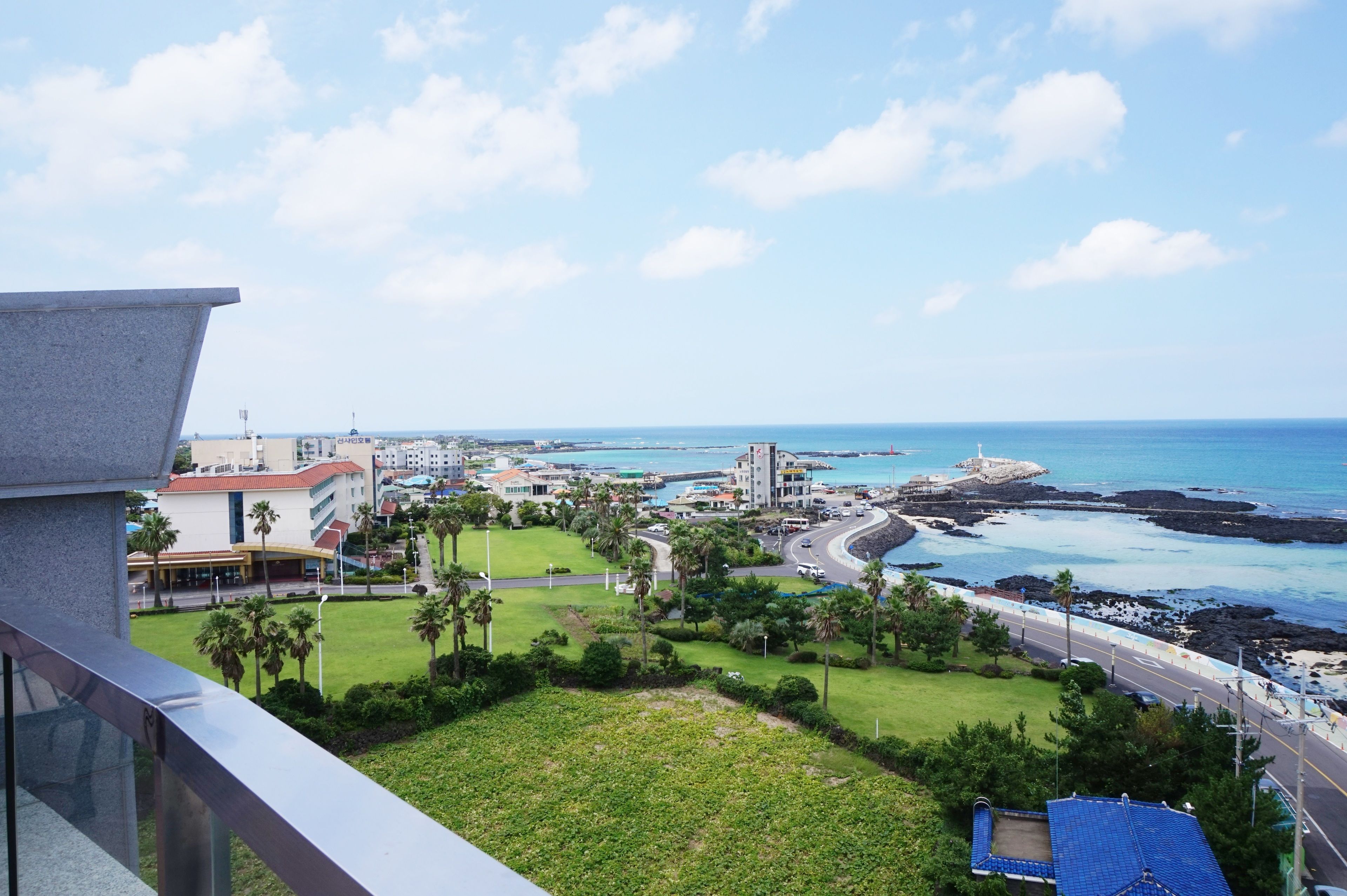 Un paisaje urbano costero con vista al mar, edificios y una zona verde.