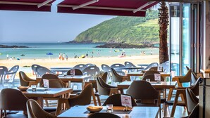 A restaurant with outdoor seating overlooking a beach.
