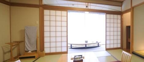 Une pièce de style japonais traditionnel, avec un sol recouvert de tatamis, une table basse et des meubles en bois.