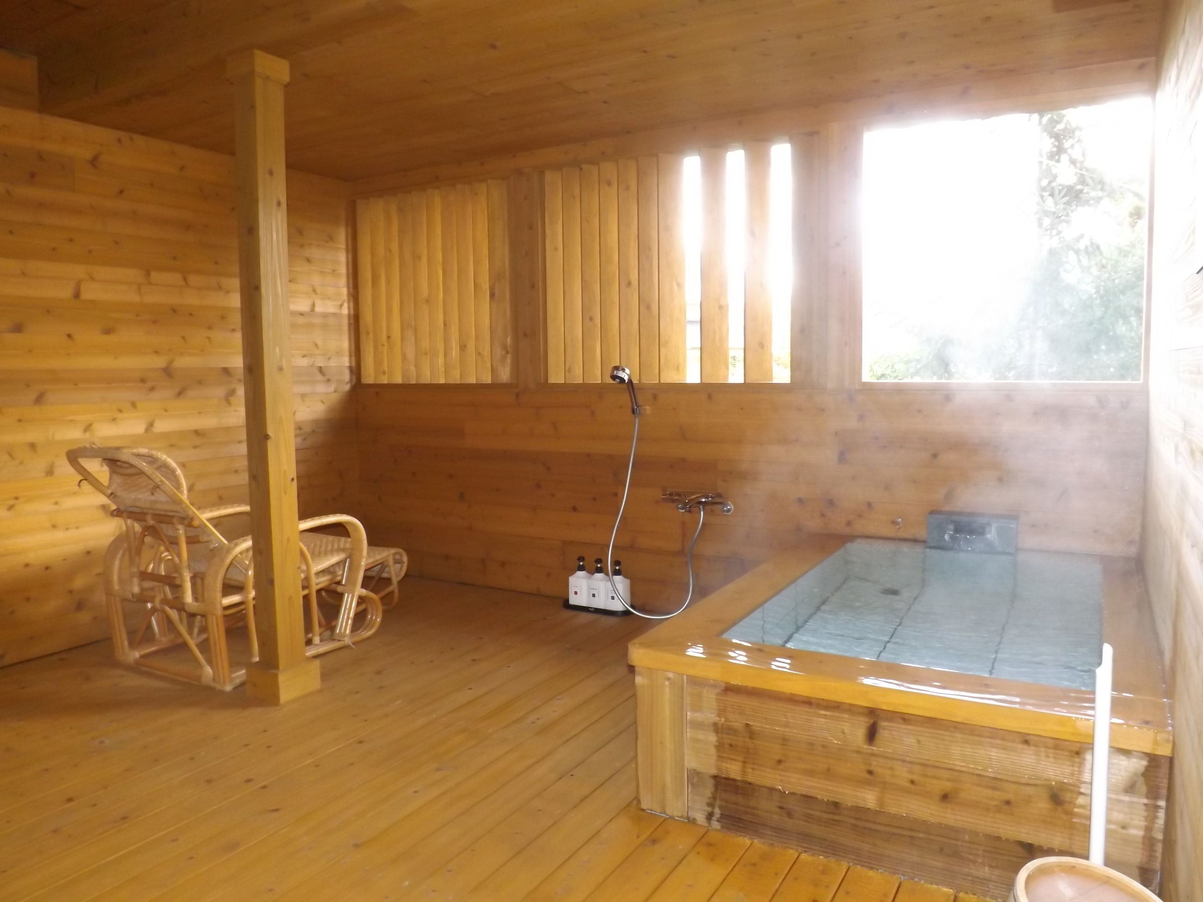 Een houten chalet met een jacuzzi, houten vloeren en een raam.