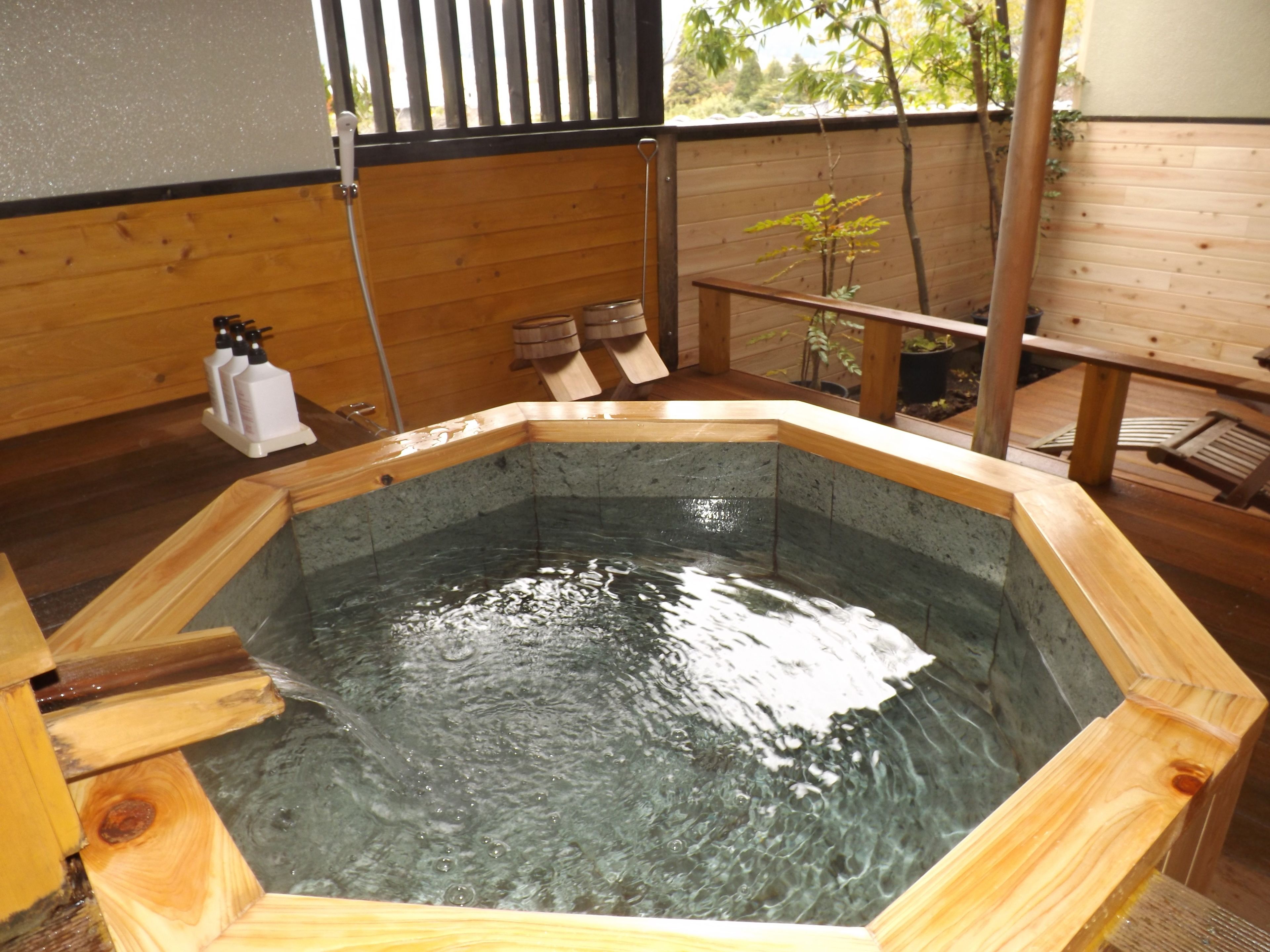 Un jacuzzi con paredes y terraza de madera.
