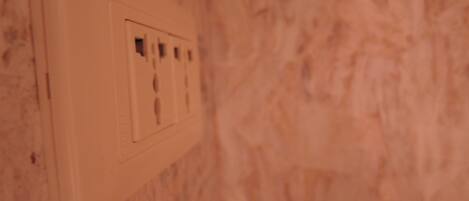 Un enchufe blanco en una pared con textura.