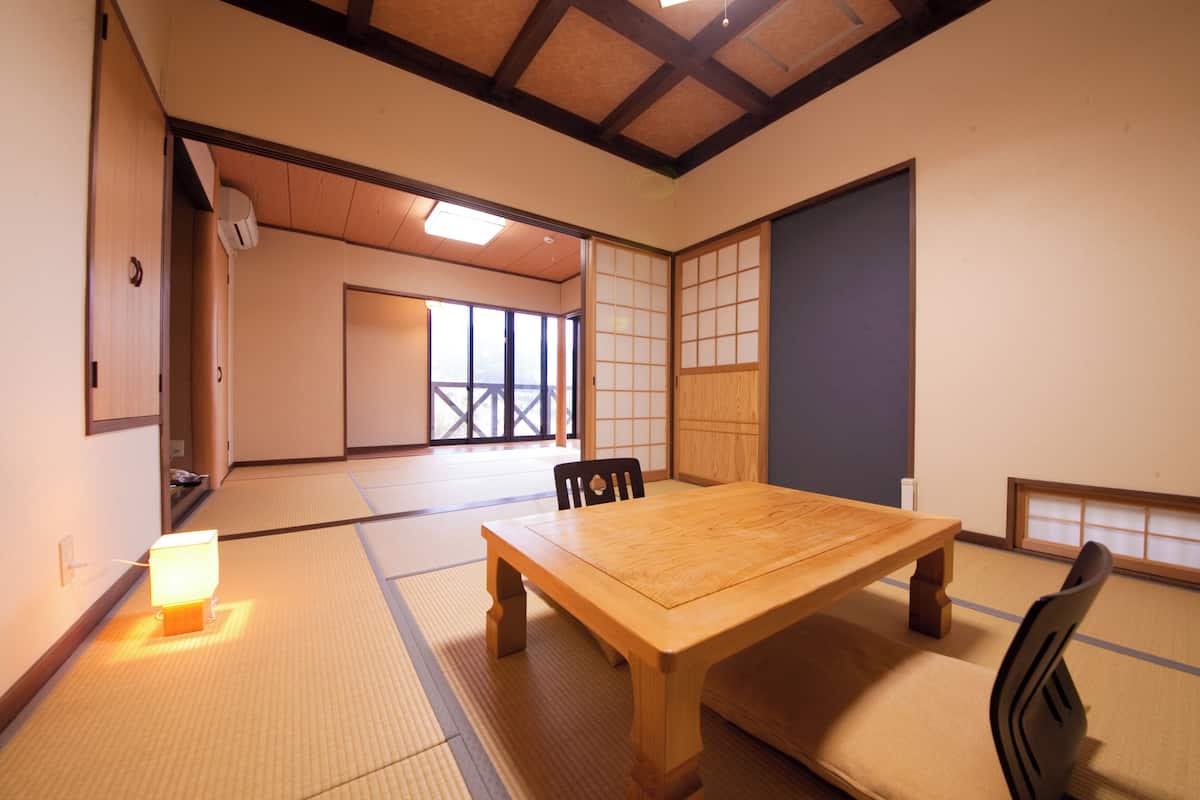 Een traditionele Japanse kamer met tatami vloerbedekking, een houten tafel en glijdende deuren.