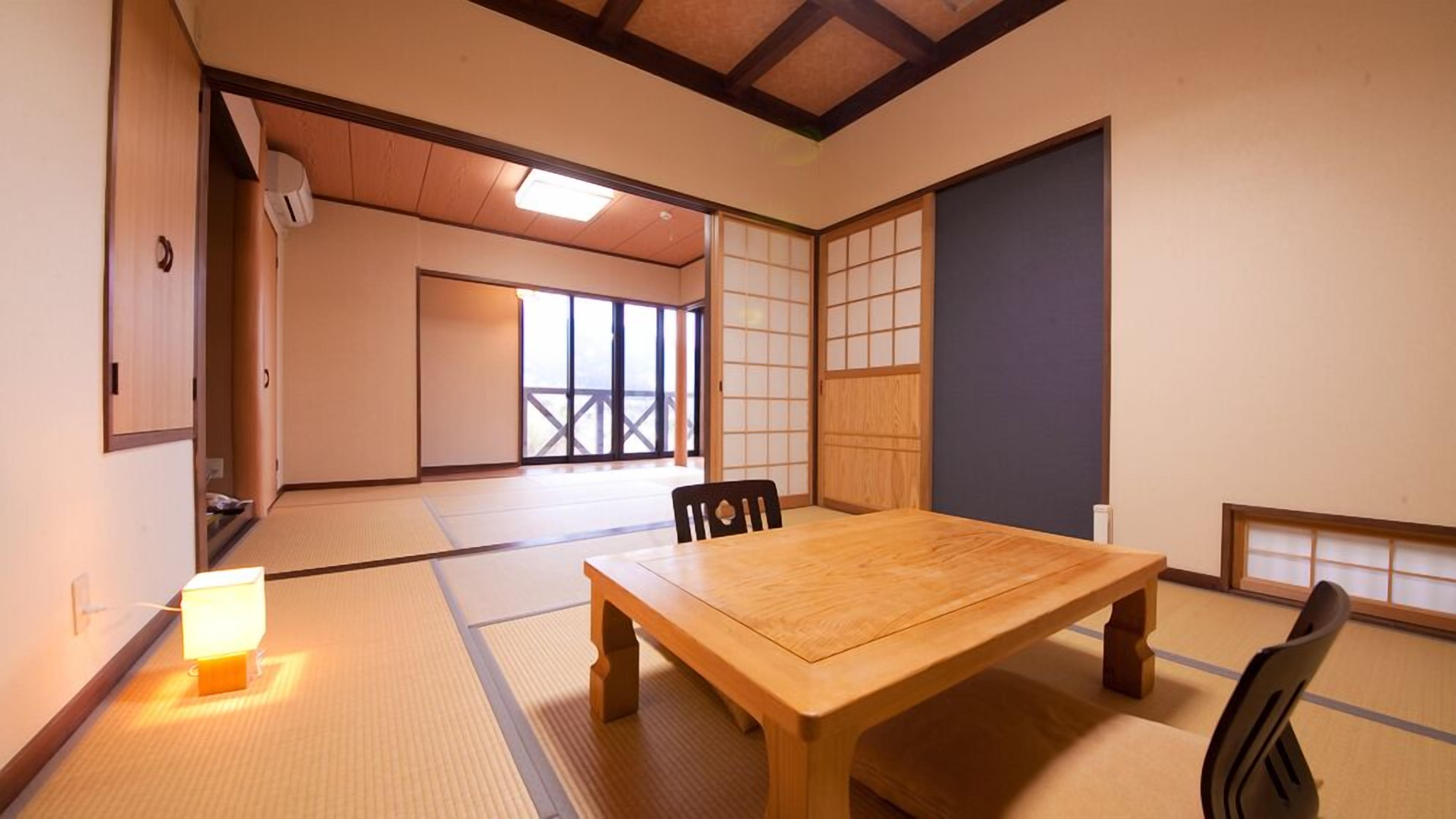 Une pièce de style japonais traditionnel, avec un sol recouvert de tatamis, une table en bois et des portes coulissantes.