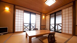 Una habitación tradicional japonesa con suelo de tatami, una mesa de madera y puertas correderas.