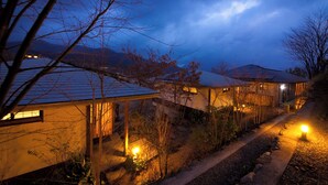 Una hilera de edificios de estilo tradicional con techos inclinados, unidos por un sendero, iluminados con una luz cálida.