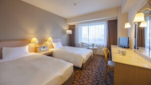 A hotel room with two beds, a desk with a computer, a chair, and a small table with a lamp. - Hotel Fujita Fukui (Fukui)