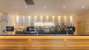 A hotel reception desk with a modern design, featuring a nameplate that reads "HOTEL FUJITA". - Hotel Fujita Fukui (Fukui)