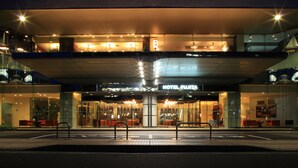 A modern hotel entrance with a glass facade, illuminated signage, and a covered walkway. - Hotel Fujita Fukui (Fukui)