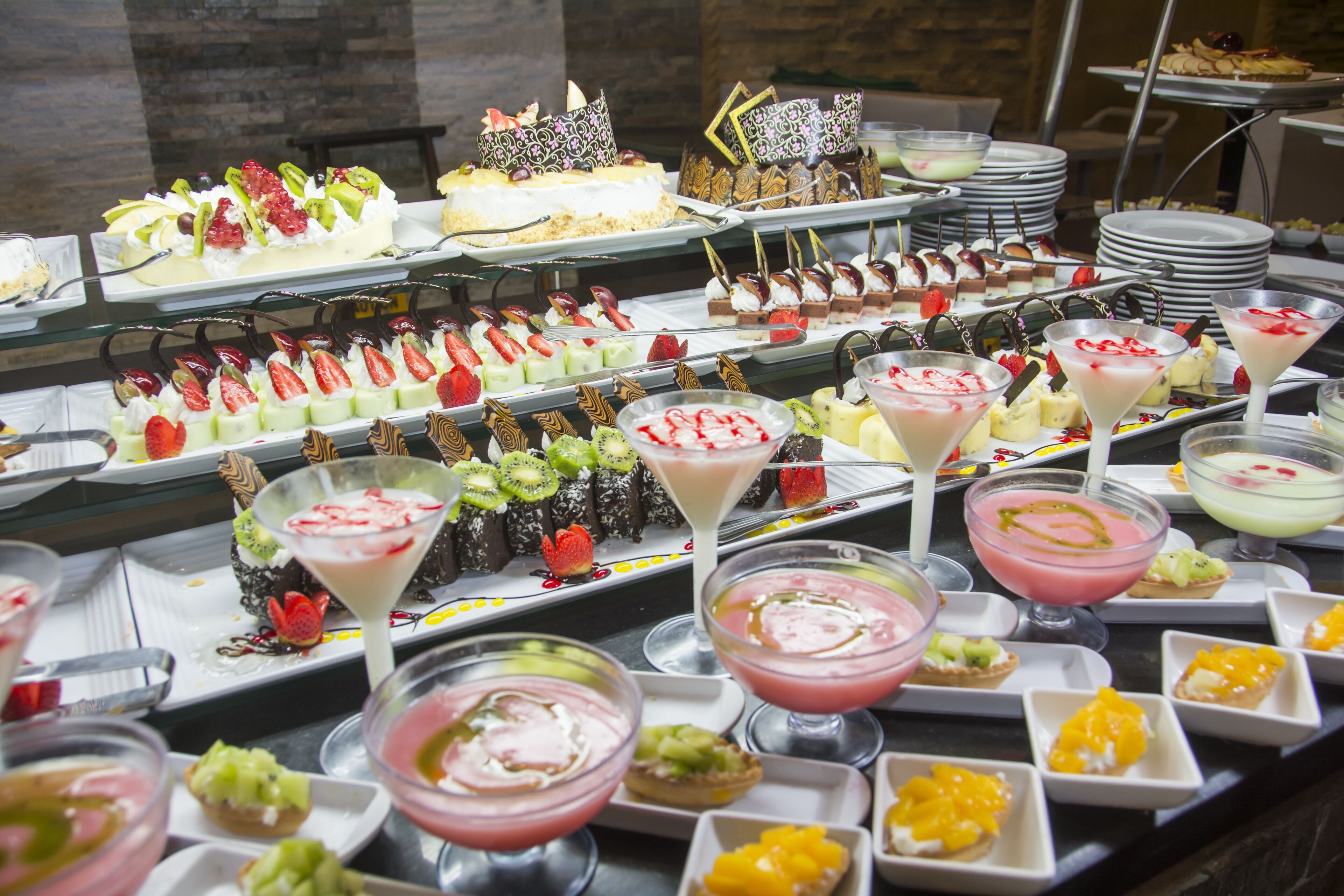 Un bufé con diversos postres y bebidas.