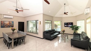A spacious living area with a dining table, two sofas, and ceiling fans. - Pattaya Hill, Near the City and Beach (Pattaya)
