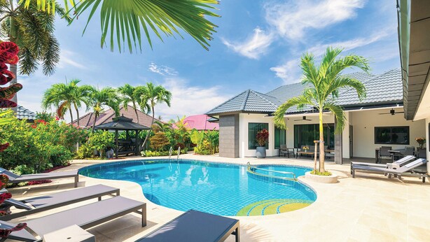 A swimming pool with lounge chairs and a gazebo, surrounded by palm trees and a modern house. - Pattaya Hill, Near the City and Beach (Pattaya)