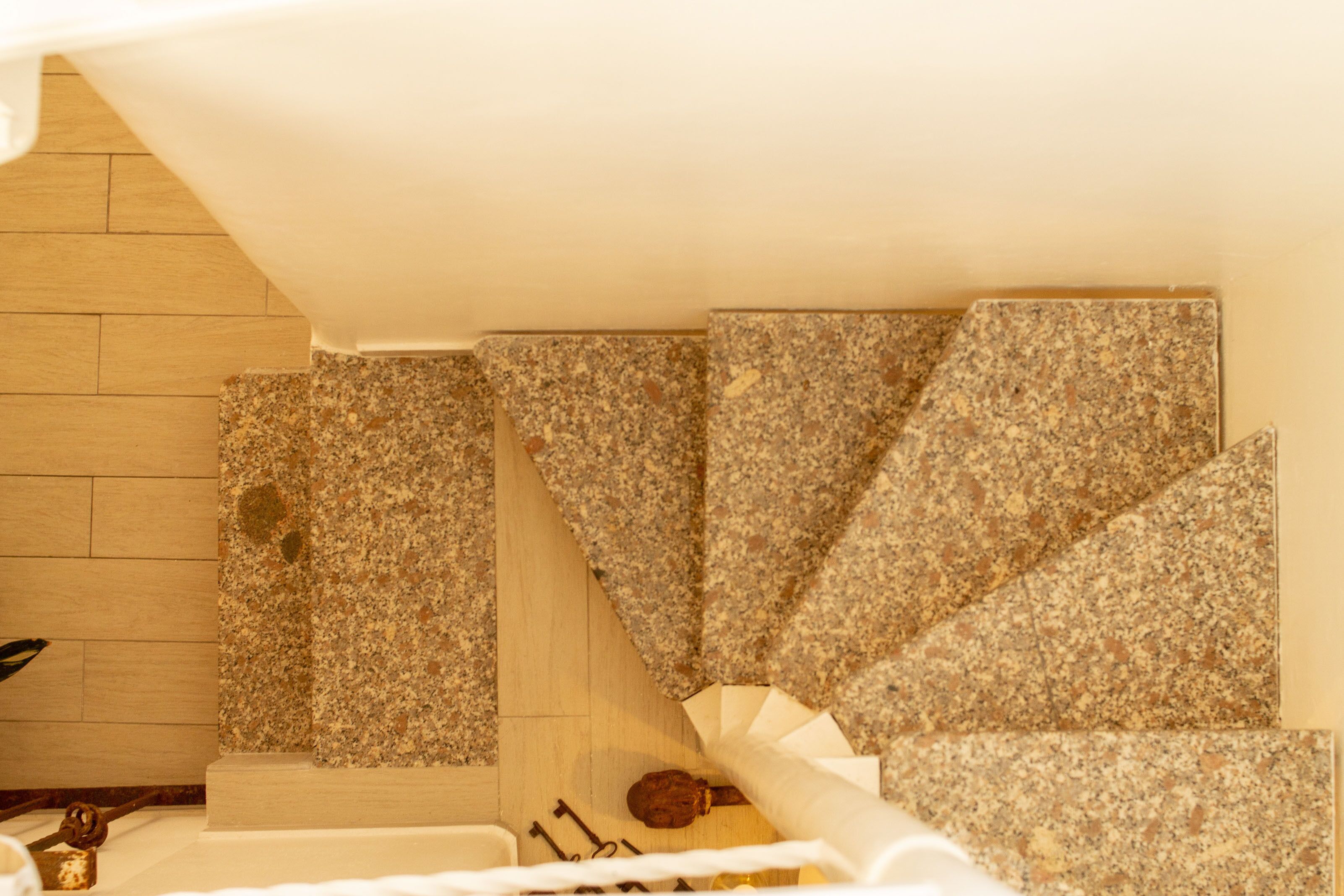 Un escalier avec des marches recouvertes de bois et un tapis à motifs.