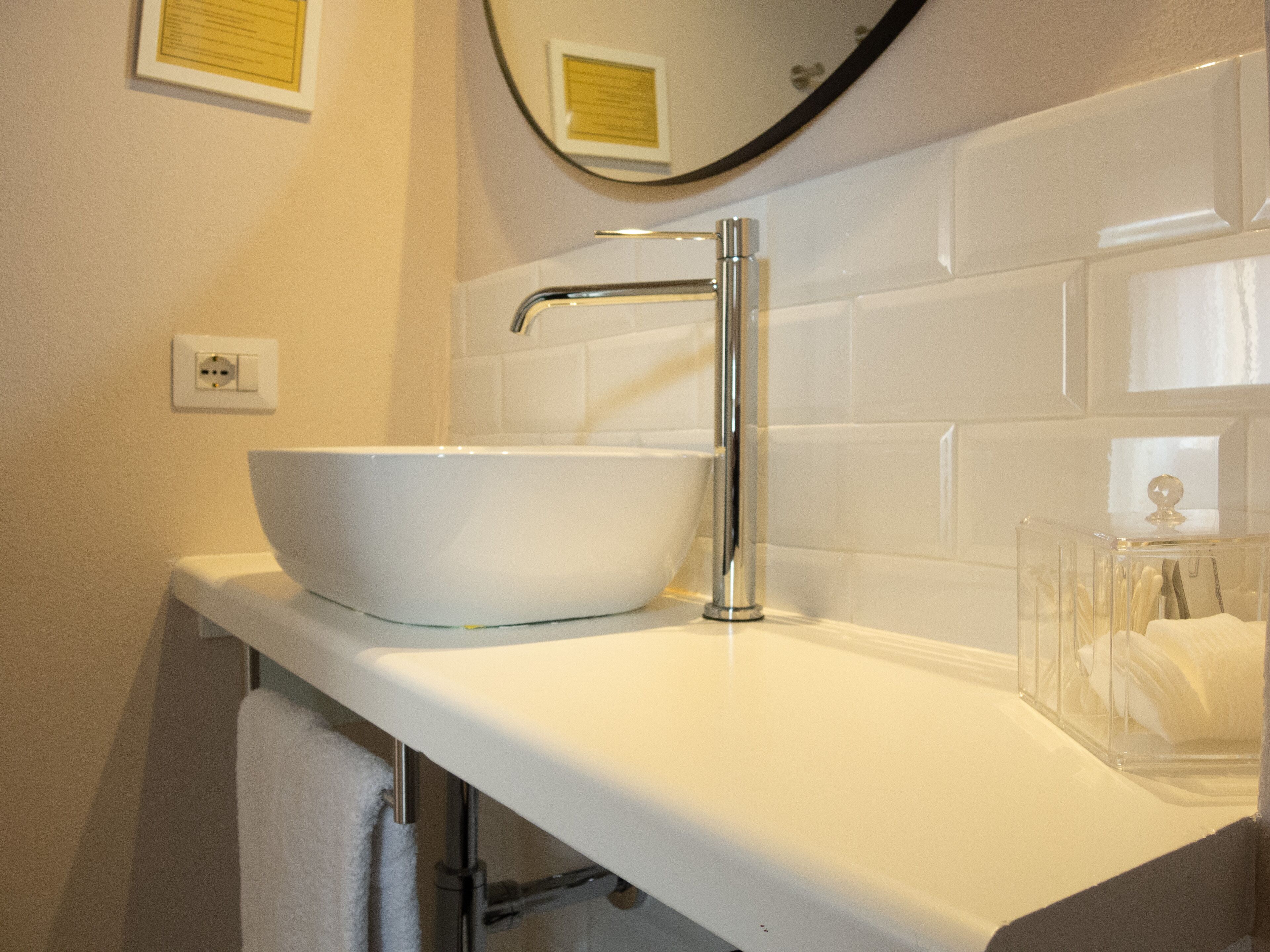 A bathroom with a white sink, chrome faucet, and a mirror above it.