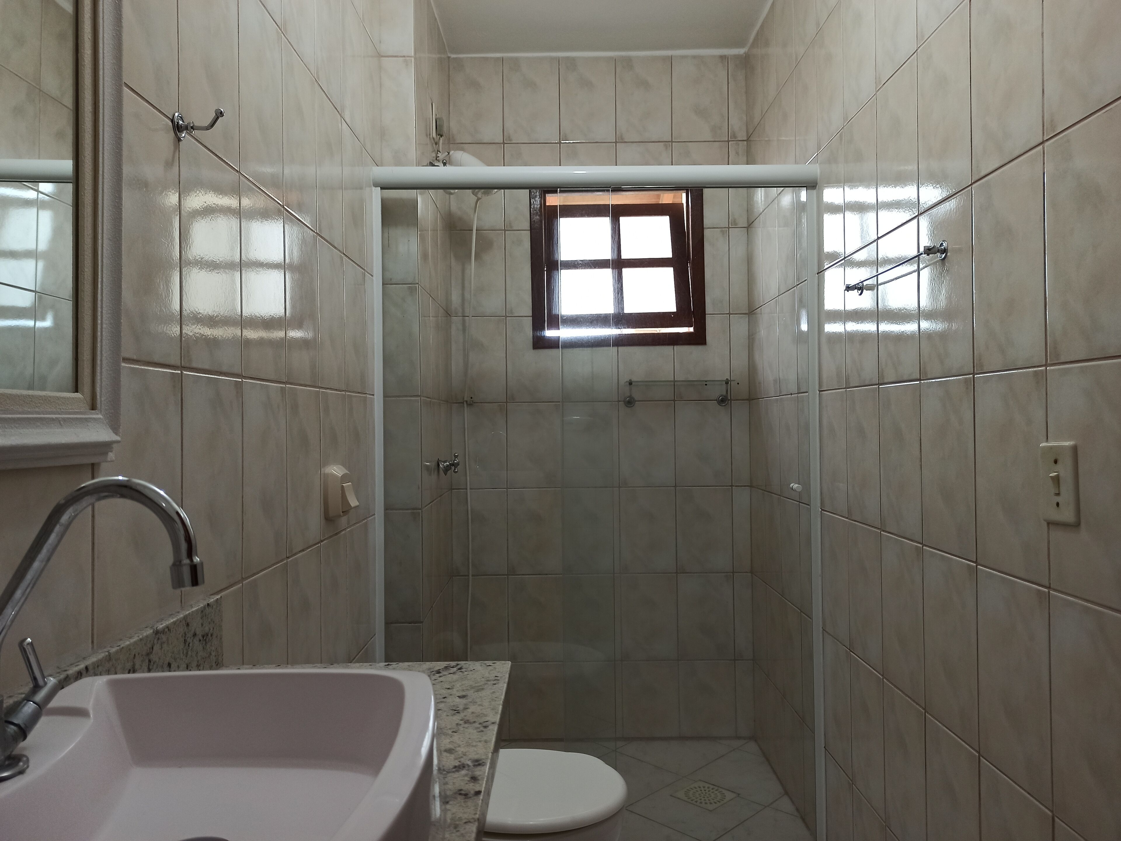 Ein kleines Badezimmer mit Waschbecken, Toilette und Duschkabine.