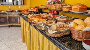A buffet with various breads, pastries, and fruits. - Pousada Magia do Sol (Florianópolis)