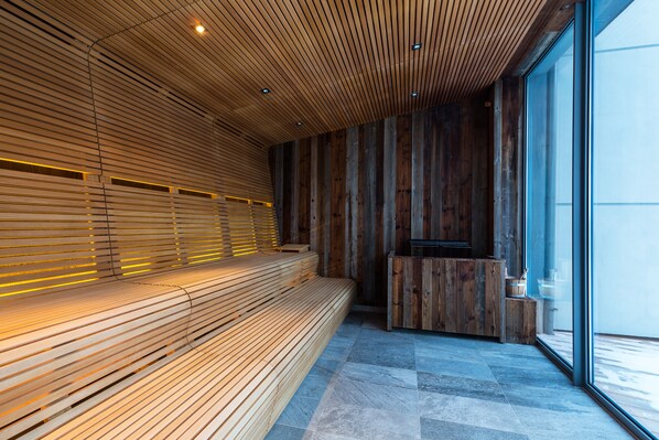 A modern interior with a wooden bench, a reception desk, and large windows.