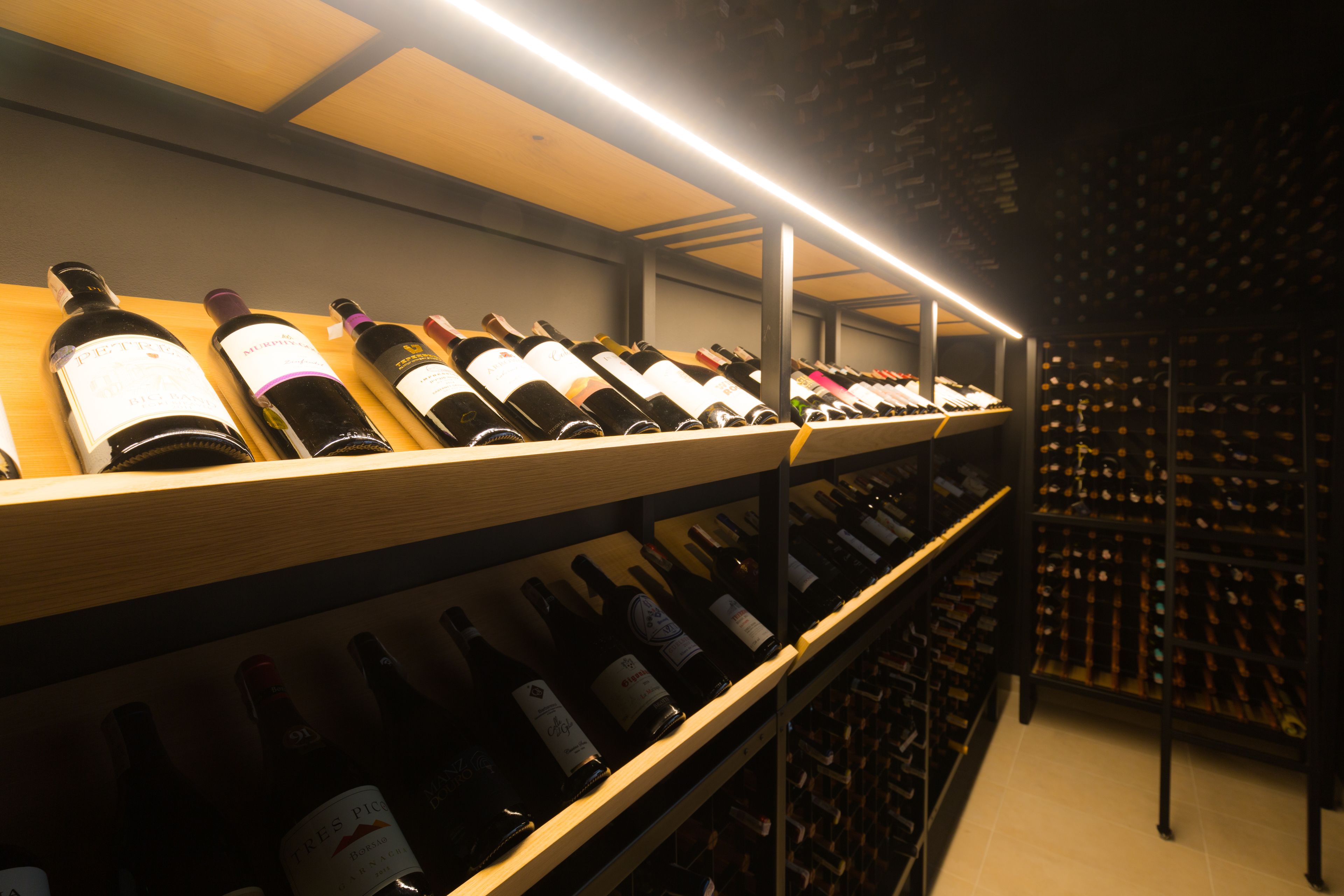 A wine cellar with shelves of wine bottles.