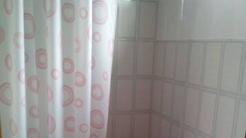 A bathroom with a shower curtain, a toilet, and a sink.