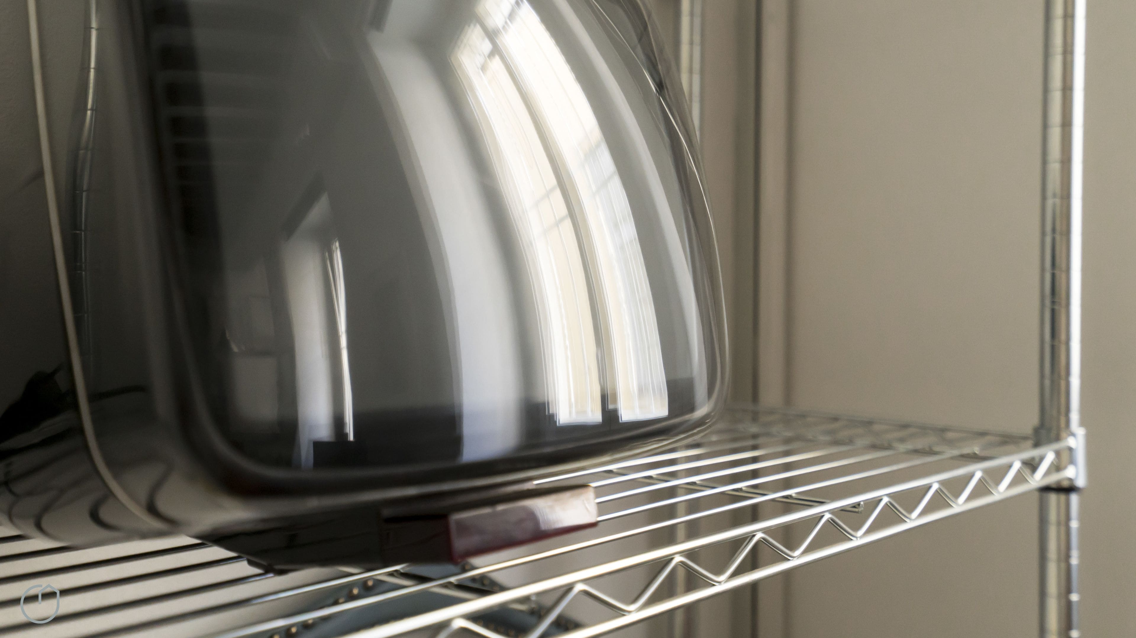 A microwave on a metal shelf.