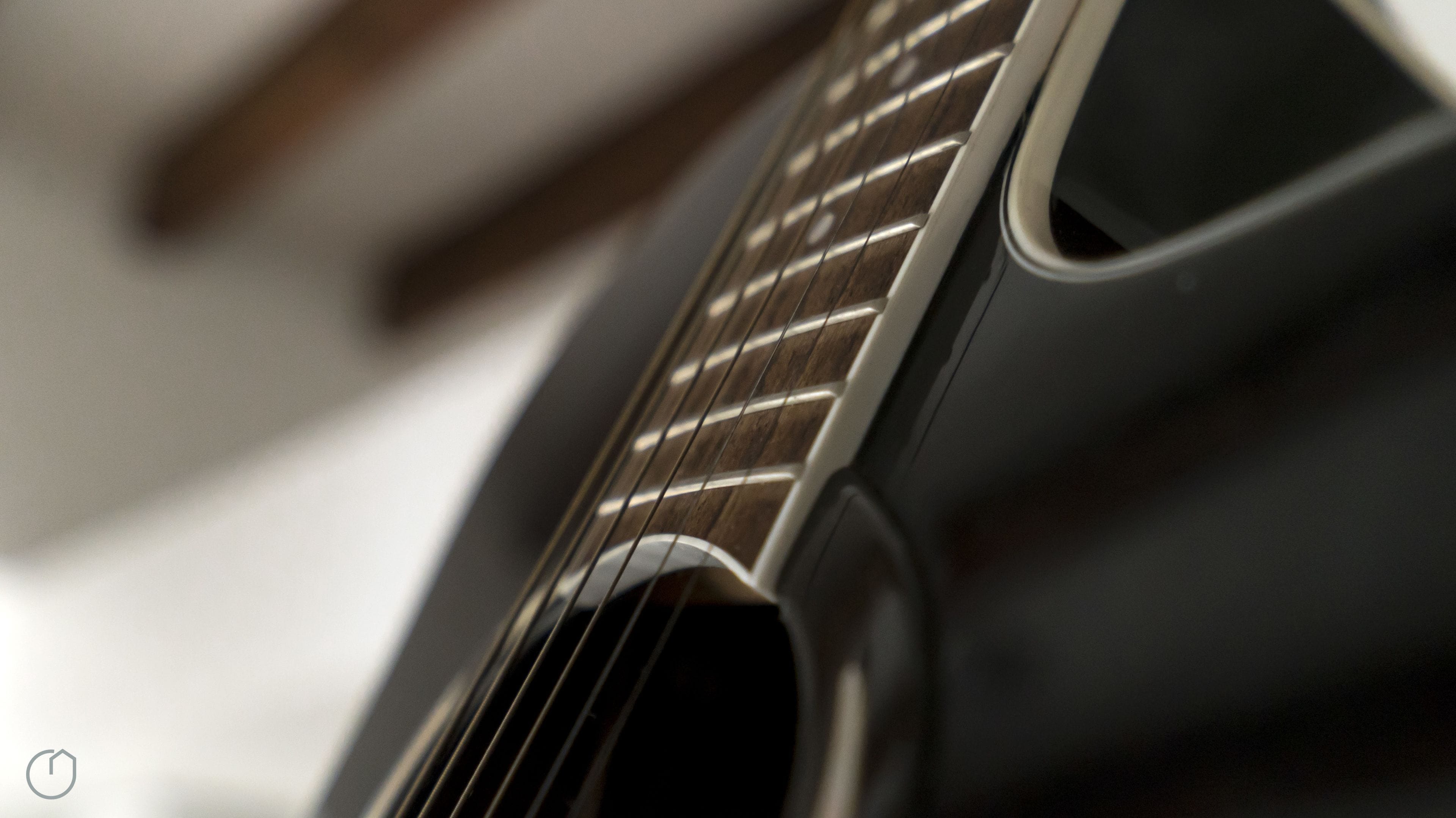 Un primo piano della cassa di risonanza e delle corde di una chitarra.