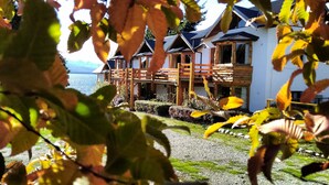 A row of wooden chalets with balconies overlooking a body of water. - Don Justo (San Carlos de Bariloche)