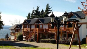 A lodge with a wooden exterior, a porch, and a view of a lake. - Don Justo (San Carlos de Bariloche)