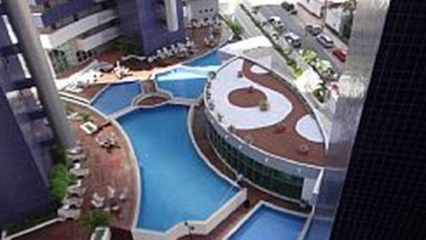 A modern hotel with a large central pool, multiple smaller pools, and a rooftop terrace with outdoor seating. - Beach Class - MeuLugarCeará (Fortaleza)
