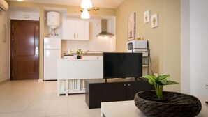 A compact kitchen with white cabinets, a built-in oven, and a black countertop.