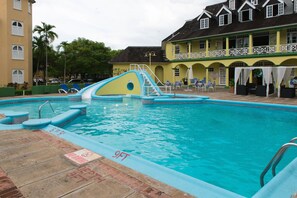Relax by the pool with lounge chairs and umbrellas, and enjoy the slide and clear water.