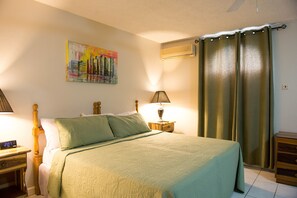 Relax in a cozy space with a comfortable bed, a bedside table, and a window with a view.