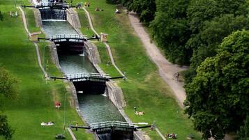 A canal with a boat passing through locks, surrounded by grassy areas and trees.