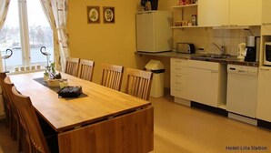 Une cuisine compacte comprenant une table à manger, des chaises, un réfrigérateur, un four à micro-ondes et un lave-vaisselle.