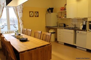 Una cocina compacta con una mesa de comedor, sillas, un refrigerador, un microondas y un lavavajillas.