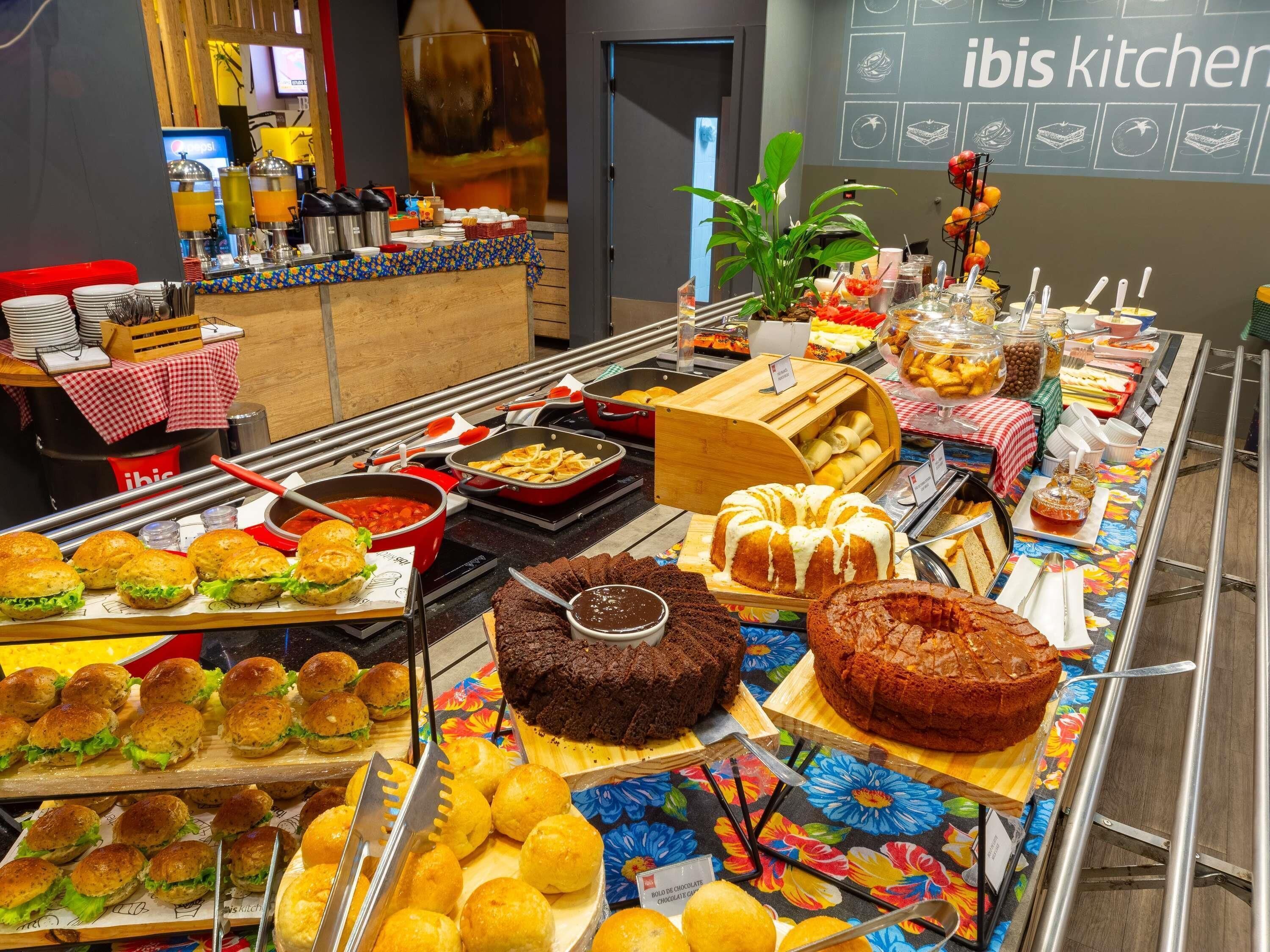 Un buffet proposant une variété de plats, notamment des sandwichs, des desserts et des boissons.