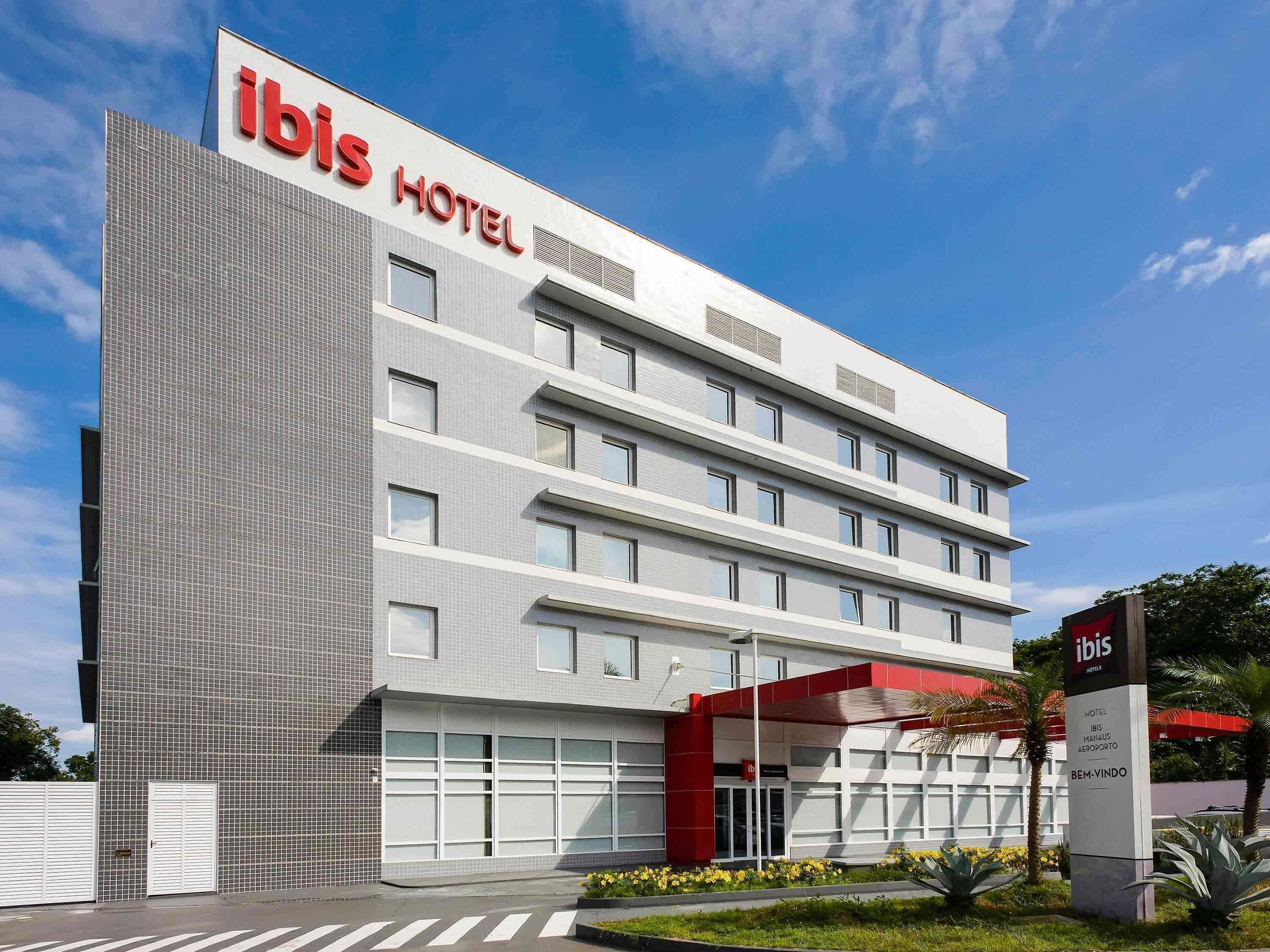 A modern ibis hotel with a tiled facade, multiple floors, and a prominent red entrance.