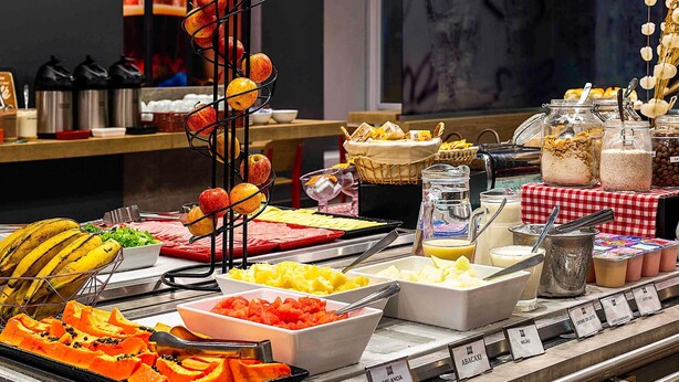 Een buffet met diverse soorten eten, zoals fruit, groenten en toevoegingen.
