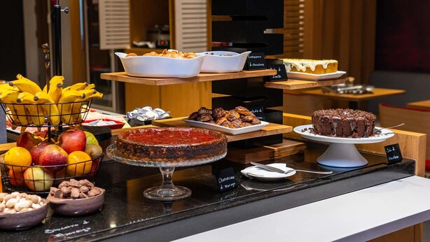 A buffet with various food items including fruits, pastries, and desserts. - ibis Chapeco (Chapecó)