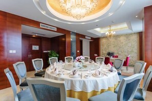 Comedor con una mesa redonda dispuesta para una comida, rodeada de sillas.