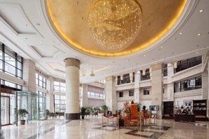 A spacious lobby with a large chandelier, high ceilings, and multiple levels. - Fliport Garden Hotel Lhasa (Laha)