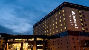 En hotelbygning med flere etager og oplyst skiltning.