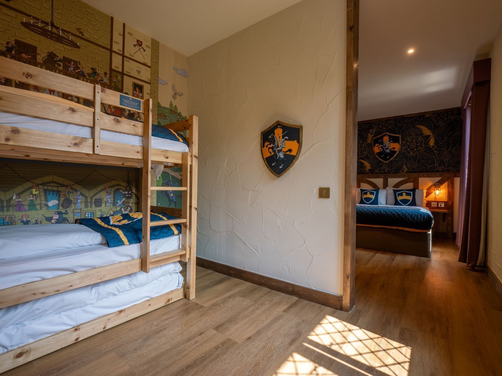 A room with a bunk bed, a mural, and a shield emblem on the wall.